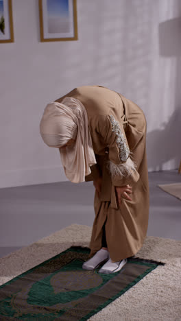 Vertical-Video-Of-Muslim-Woman-Wearing-Hijab-At-Home-Praying-Kneeling-On-Prayer-Mat-3